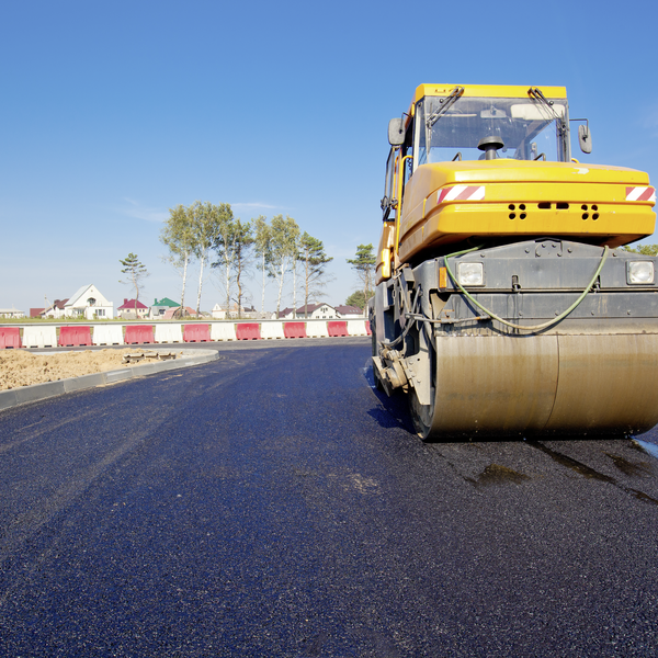 gelbe Walze verdichtet frischen, schwarzen Asphalt auf einer neuen Straße gelbe Walze verdichtet frischen, schwarzen Asphalt auf einer neuen Straße